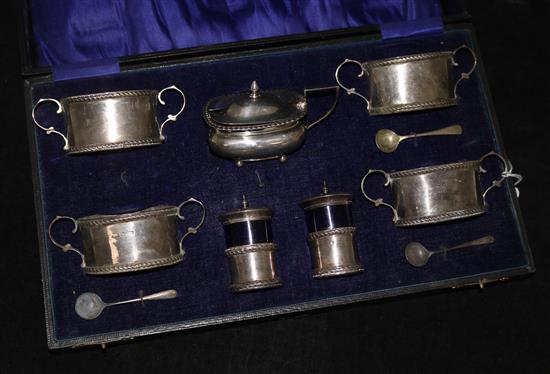 A George V silver seven piece condiment set, cased